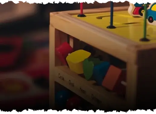 Zdjęcie drewnianej zabawki edukacyjnej dla dzieci z kształtami w przedszkolu w Krakowie.